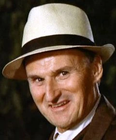 Portrait photo of Charles Tyner wearing a light-colored hat and smiling