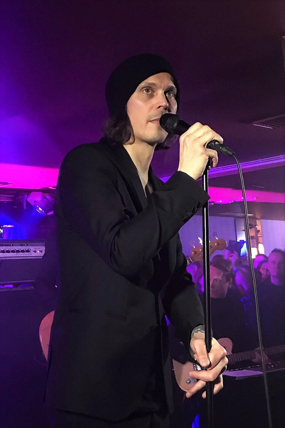 Ville Valo performing on stage, singing into a microphone