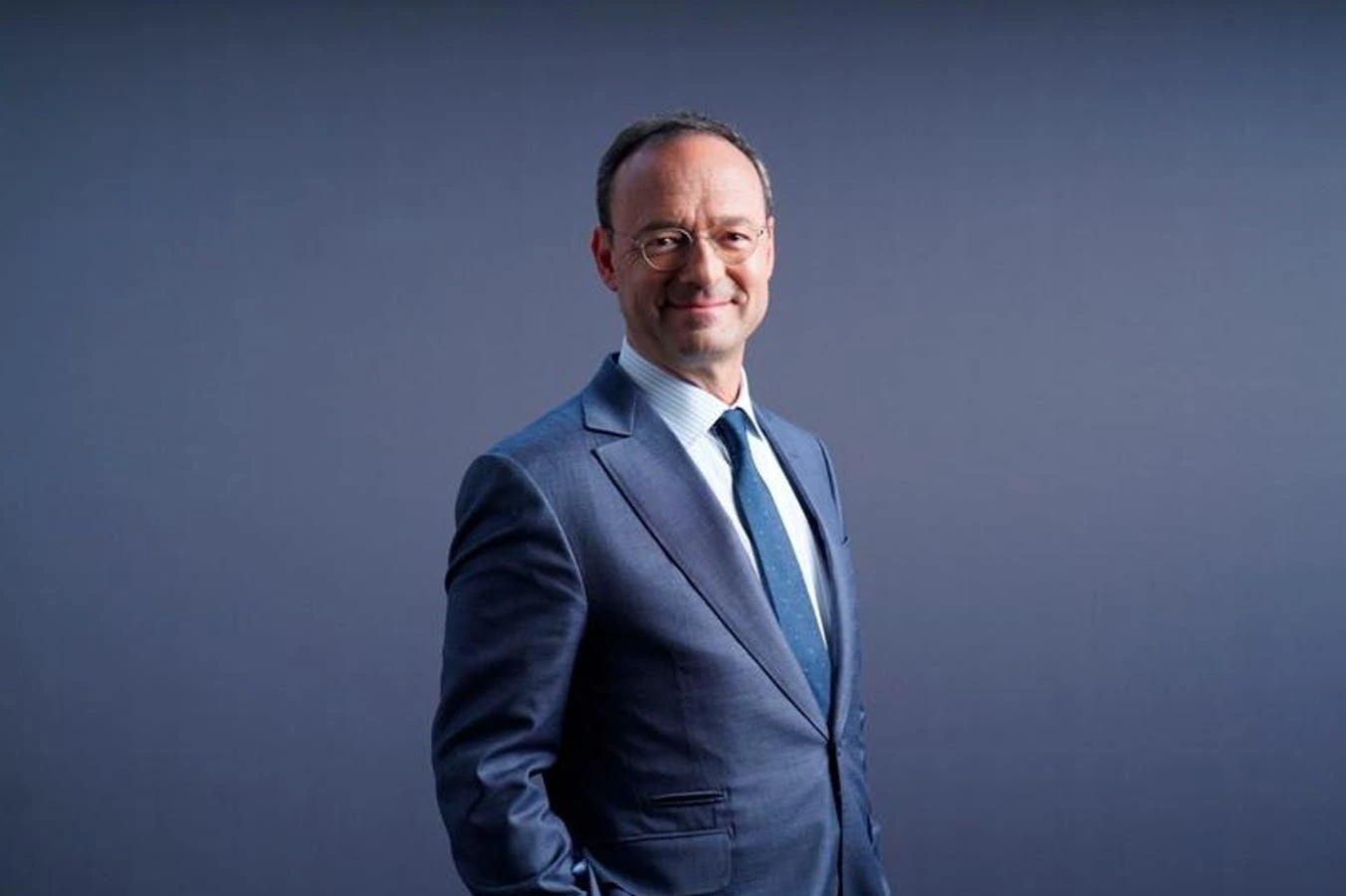 Portrait photo of Jean Salata in a blue suit against a plain background