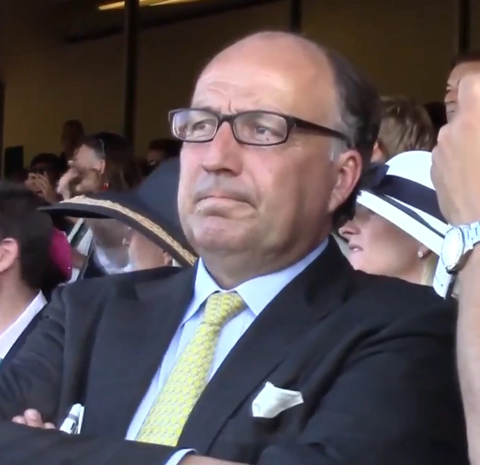 Christophe Clément speaking at an event, wearing a suit and glasses