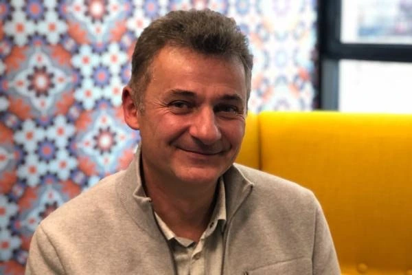 Thierry Cruanes smiling in an indoor portrait photo