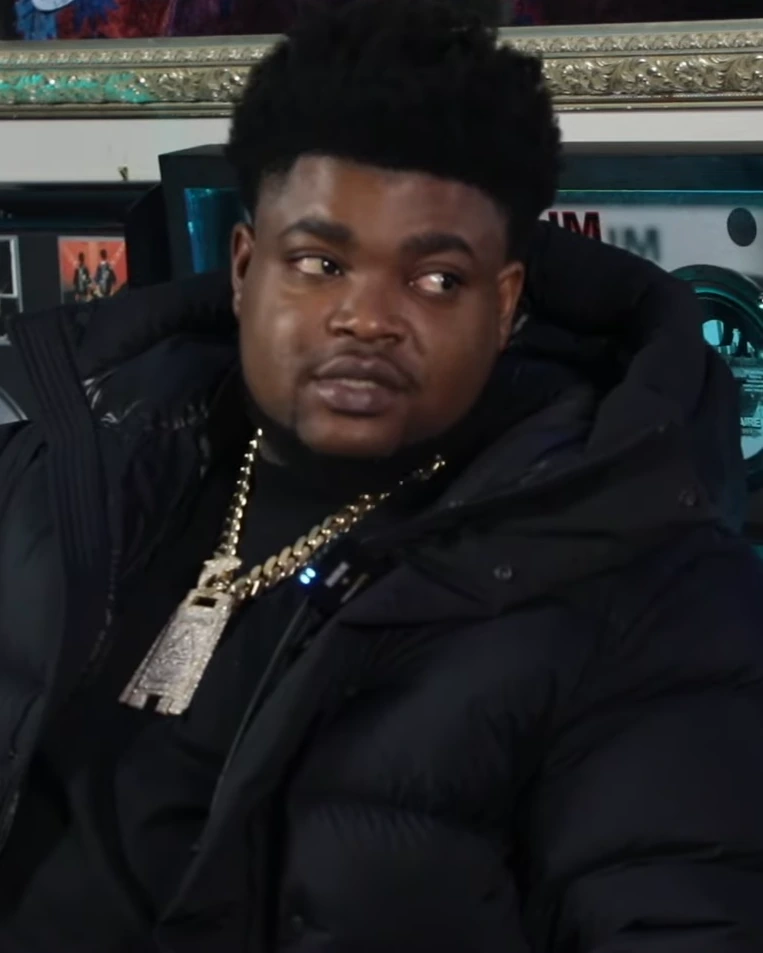 BossMan Dlow in an interview, wearing a black jacket and chain necklace