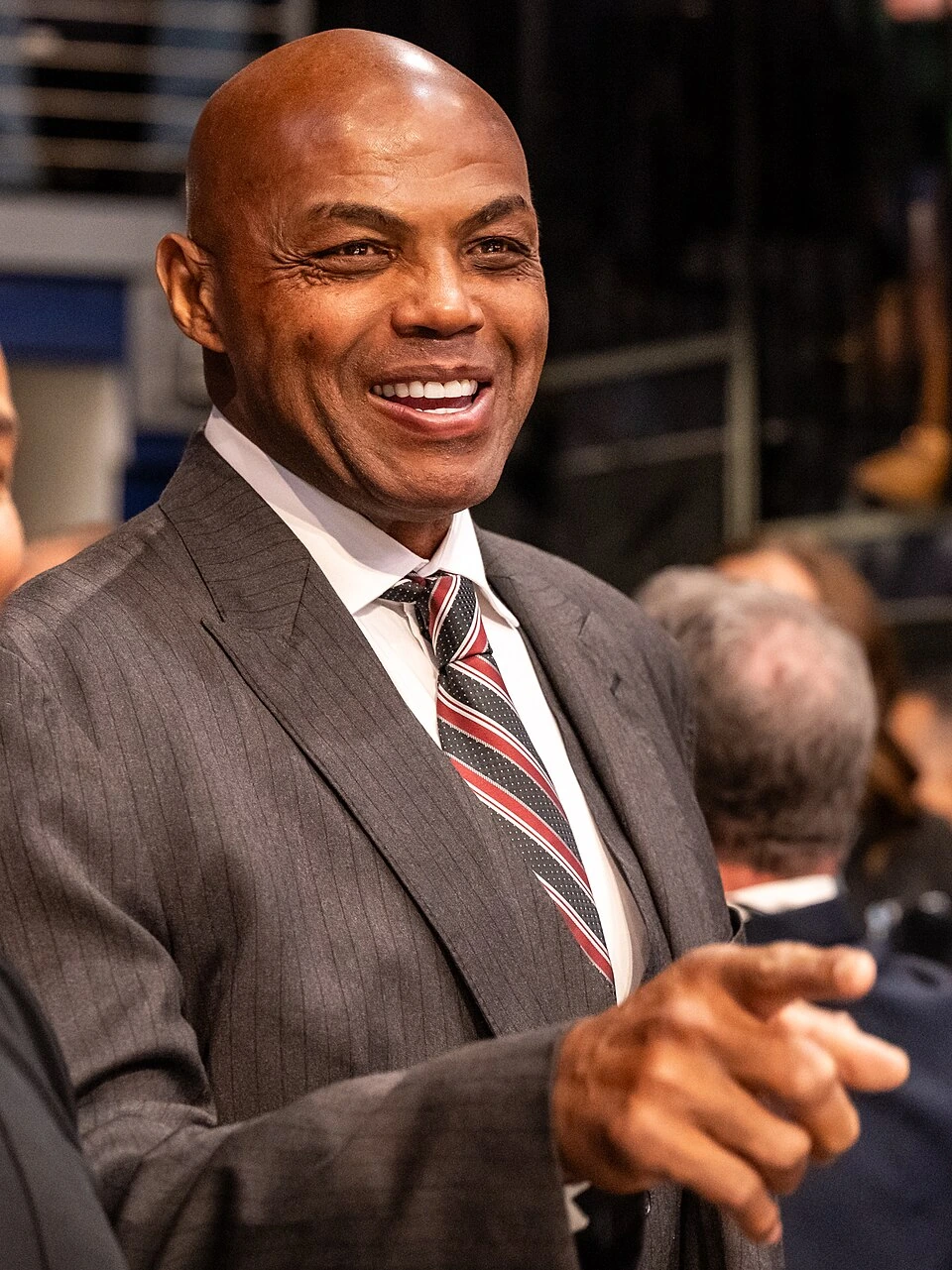 Charles Barkley smiling in a suit and tie at an event