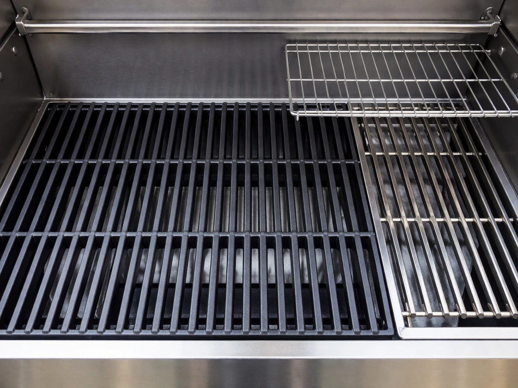 Top-down view of a grill cooking grate with warming rack, showing a compact cooking area with scale