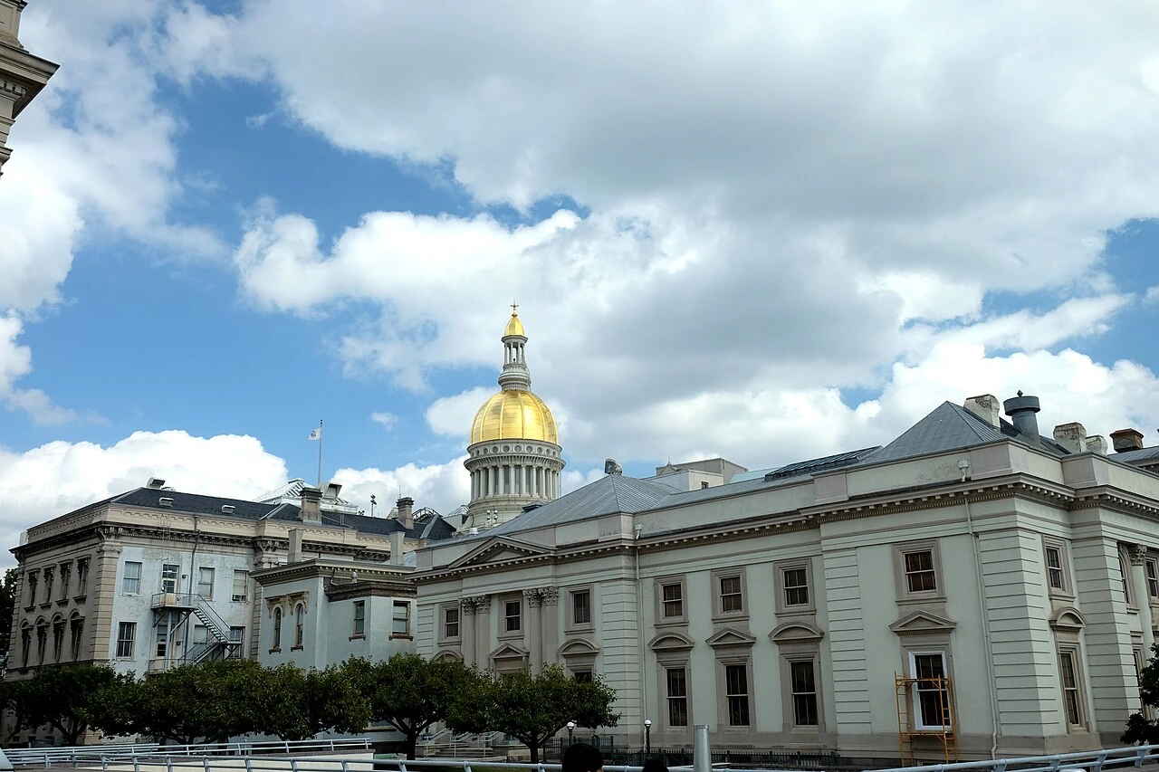 New Jersey State Capitol building in Trenton, New Jersey, with the gold dome against a cloudy sky.