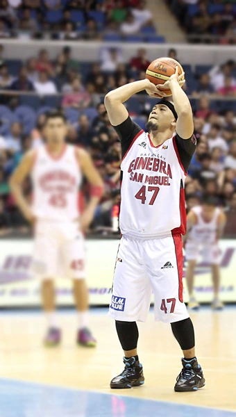 Mark Caguioa shooting a basketball in a game, wearing a Ginebra San Miguel jersey.