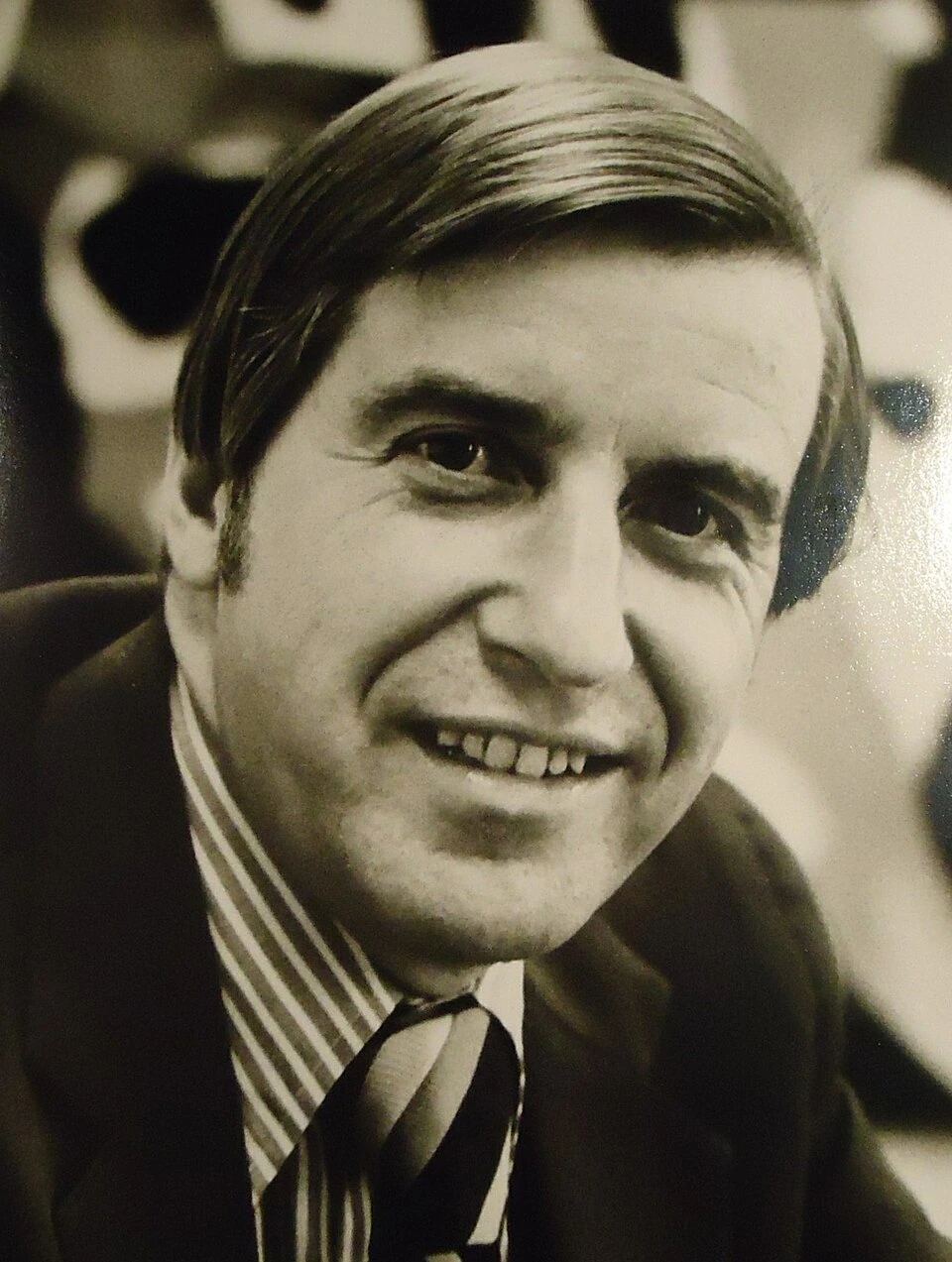 Black-and-white portrait photo of an advertising executive smiling in a suit and tie.