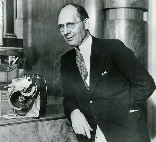 Black-and-white portrait of Charles Franklin Kettering standing beside mechanical equipment