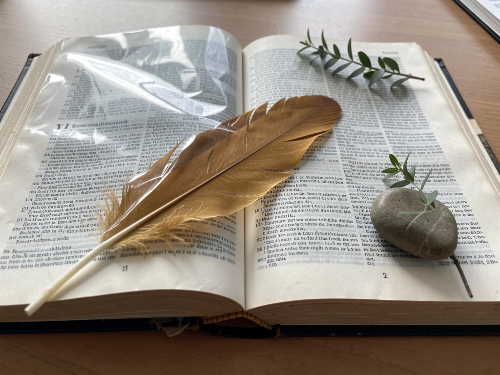 Eagle-related name inspiration shown with a golden eagle feather and a classical-style etymology dictionary open to a bl