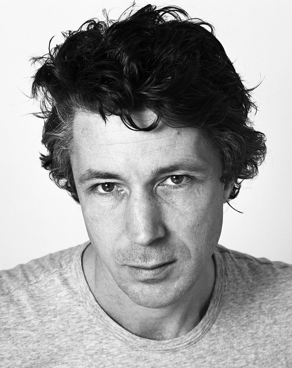 Black-and-white portrait of Irish actor Aidan Gillen against a plain background