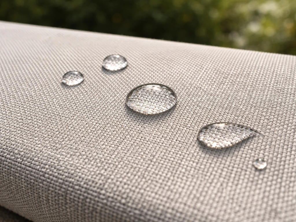 Close-up of solution-dyed polyester/olefin fabric weave with water droplets beading on the surface.