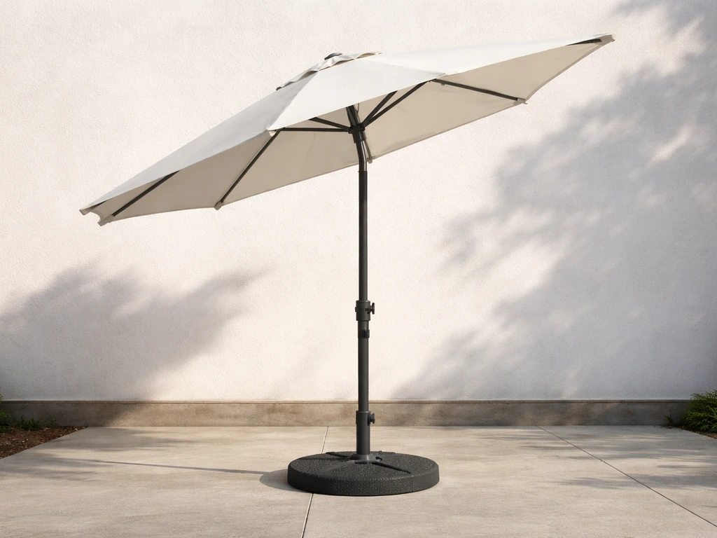 Patio umbrella anchored in a heavy weighted base on a concrete patio, slightly tilted to show wind stability.
