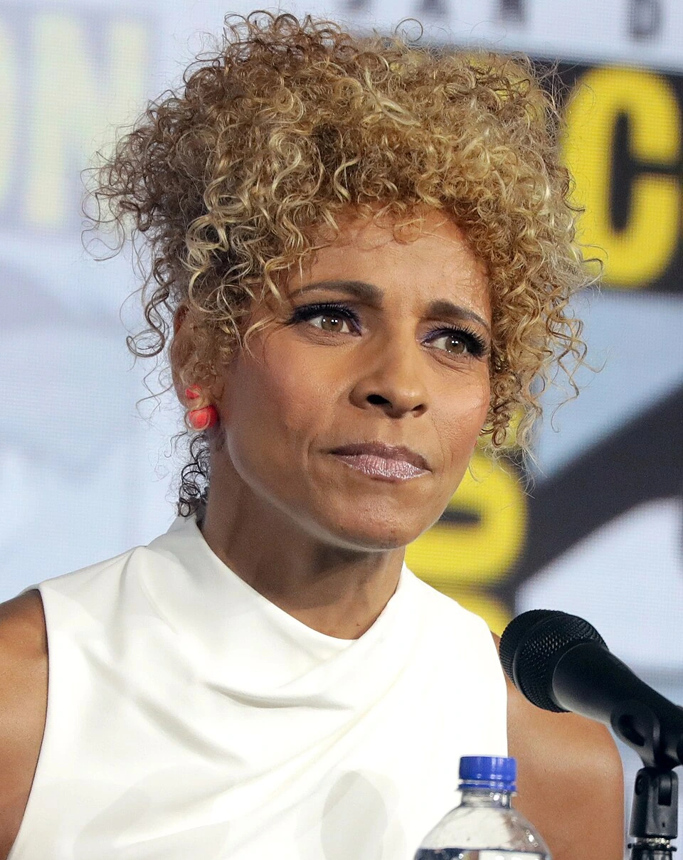 Michelle Hurd speaking at an event, photographed in close-up