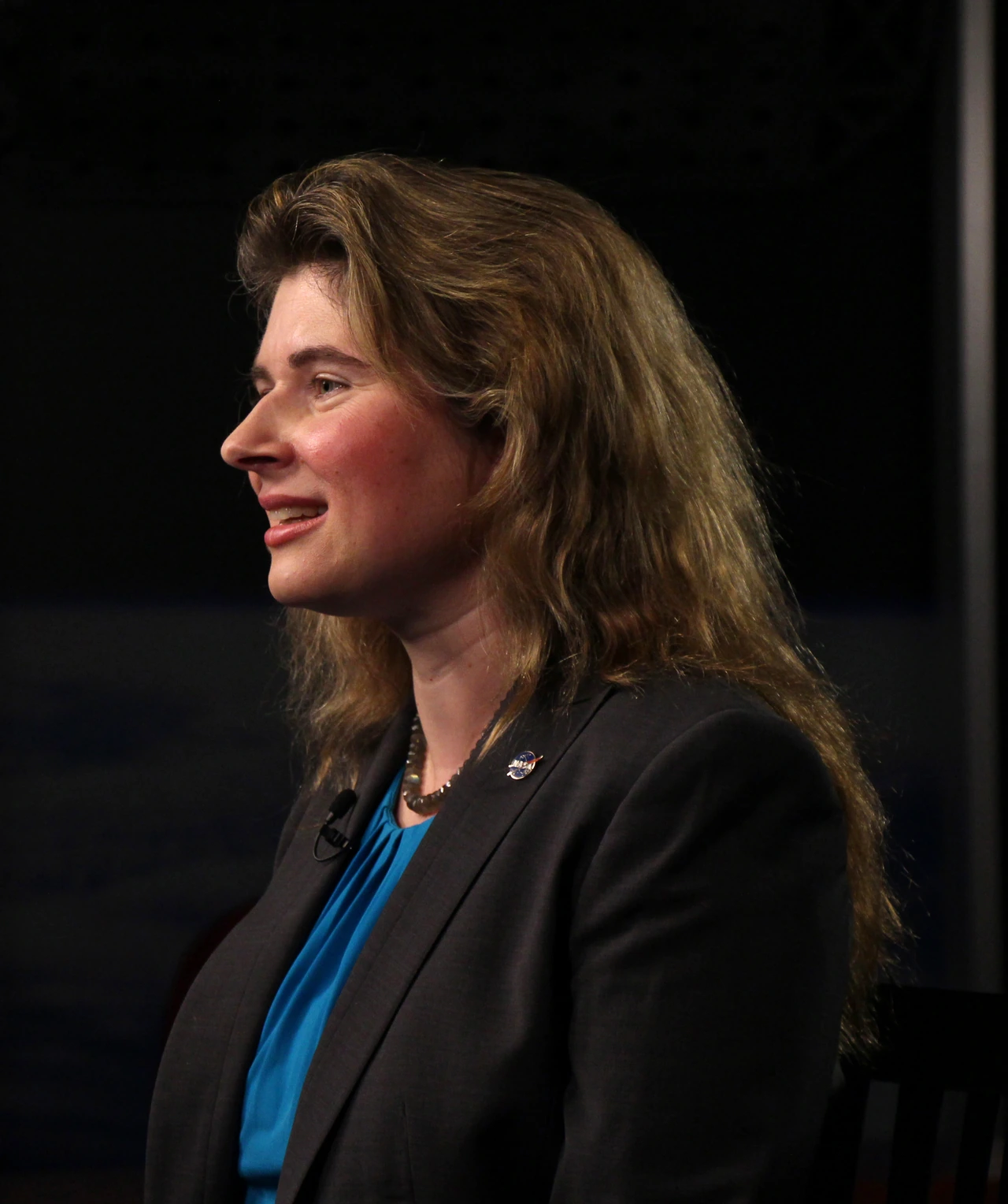 Michelle Thaller speaking on stage in a documentary-style portrait