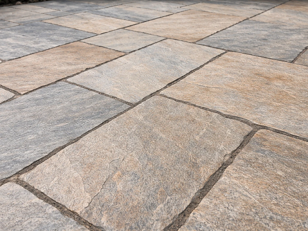 Close-up of split flagstone slabs laid for an outdoor patio, showing natural stone texture and grout lines.