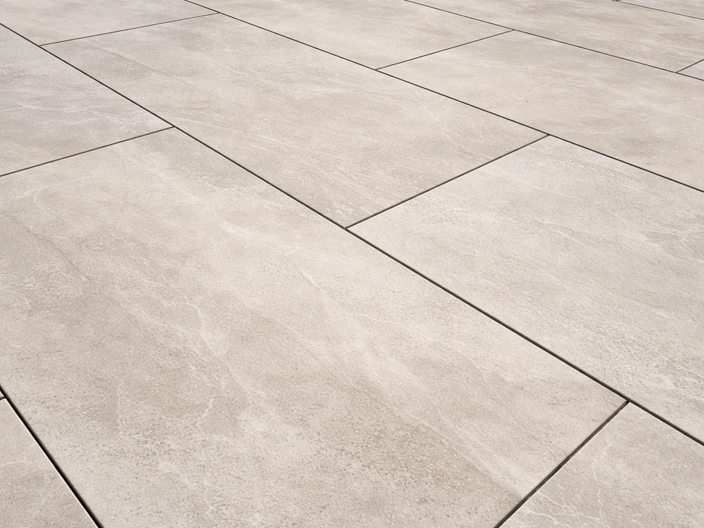 Close-up of large-format porcelain pavers with tight, seamless joints on a modern patio.