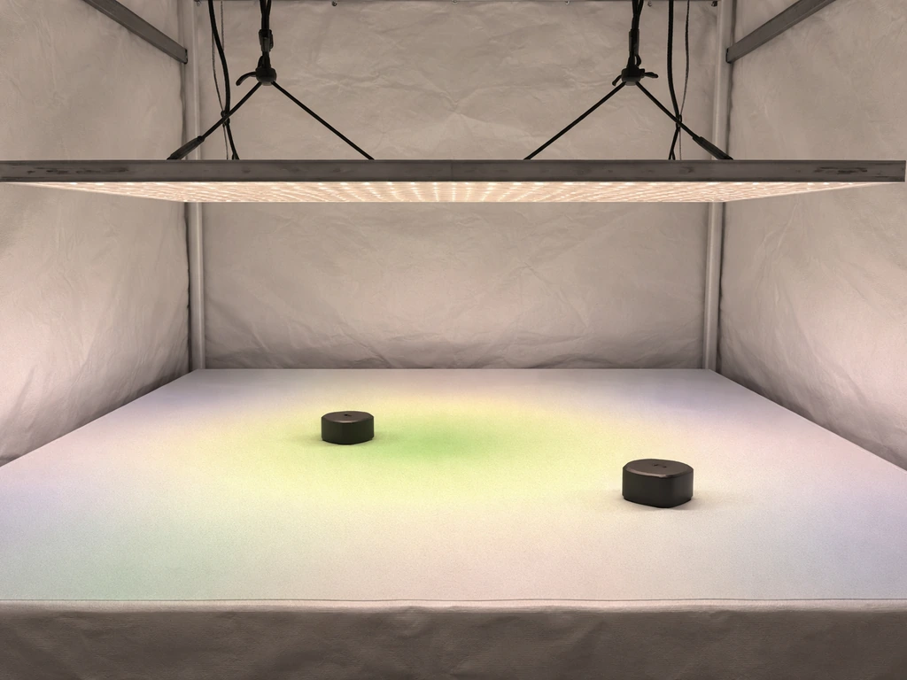 Grow tent canopy with center and edge sensors and subtle colored light spill showing uniform PPFD spread.