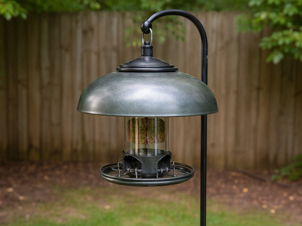Weight-activated bird feeder shroud/baffle in place on a backyard pole