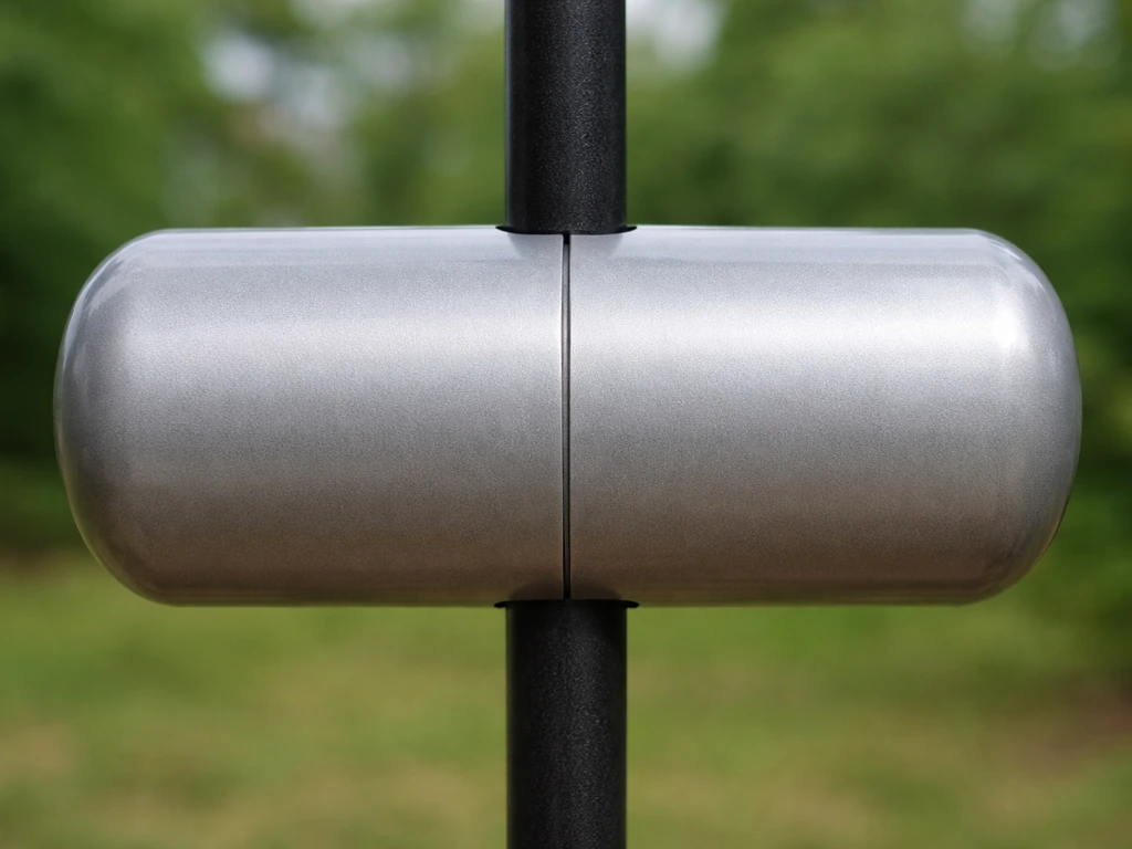 Close-up of a smooth torpedo tube baffle wrapped around a feeder pole, blocking squirrel footholds.