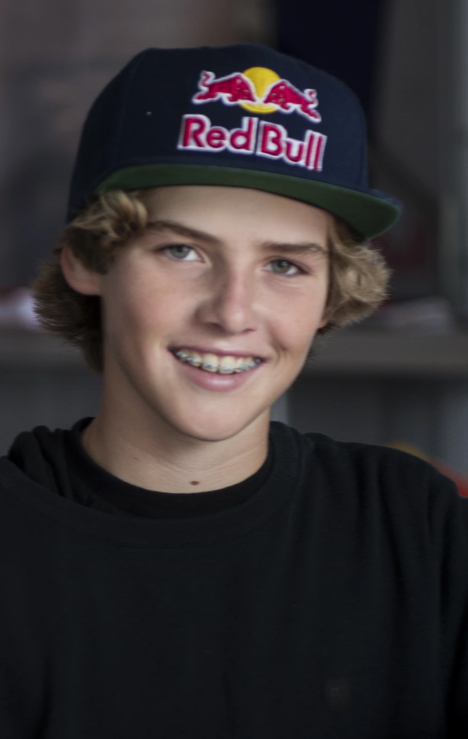 Tom Schaar smiling in a close-up portrait wearing a Red Bull cap.