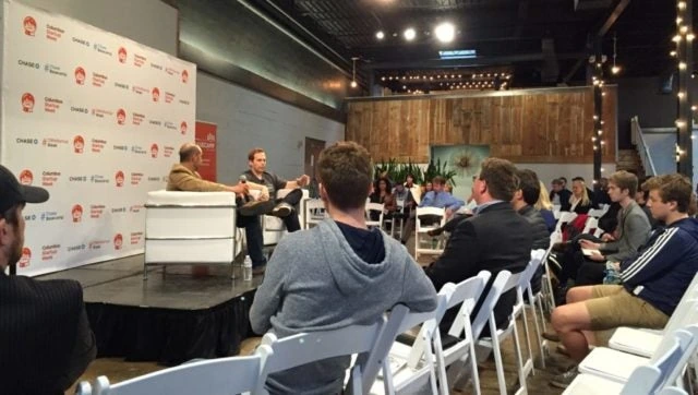 Wil Schroter speaking on stage at a startup event in front of an audience