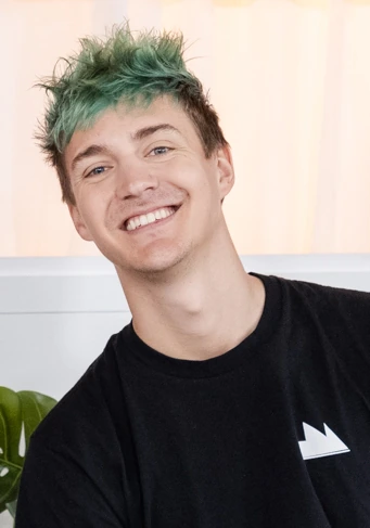 Tyler Blevins, known as Ninja, smiling in a casual portrait with green hair.