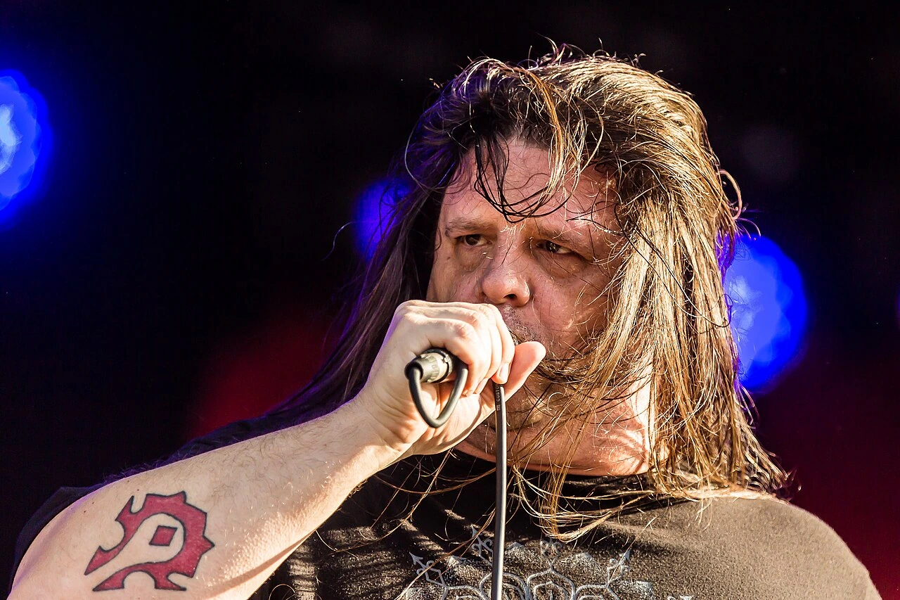 George Fisher (Corpsegrinder) performing with Cannibal Corpse onstage, holding a microphone.