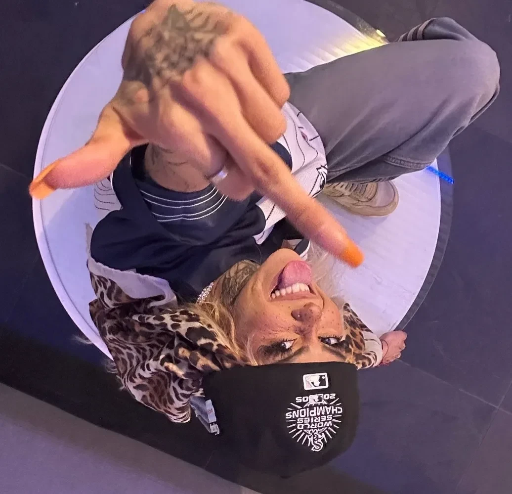 BeastEater posing playfully in a candid, upside-down photo with a visible hand gesture and casual streetwear