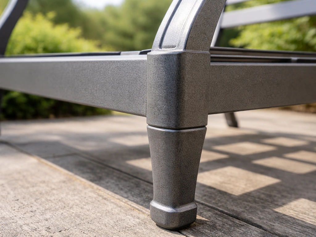 Close-up of a powder-coated aluminum chair frame and die-cast leg outdoors in natural light.