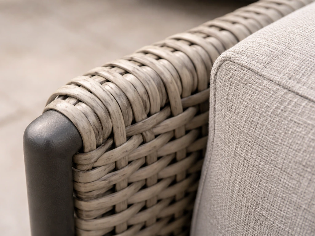 Close-up of hand-woven PE wicker over a powder-coated steel frame with olefin cushion fabric texture.