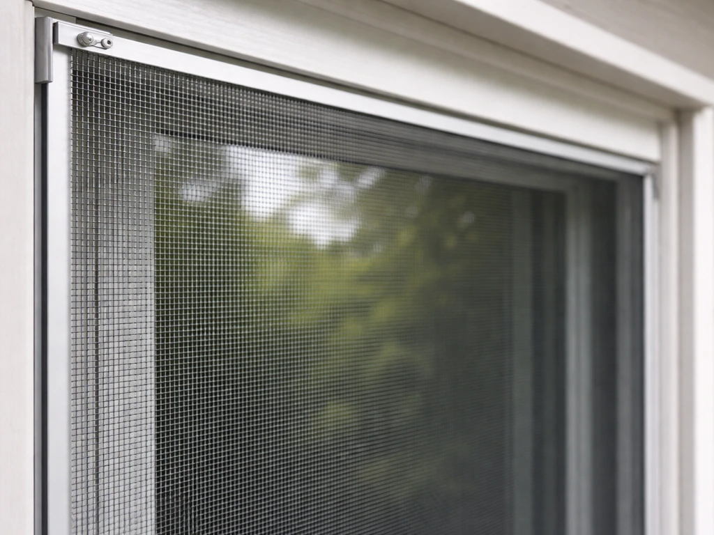 Close-up of bird-safe window mesh set a few centimeters from the glass, showing the protective gap.