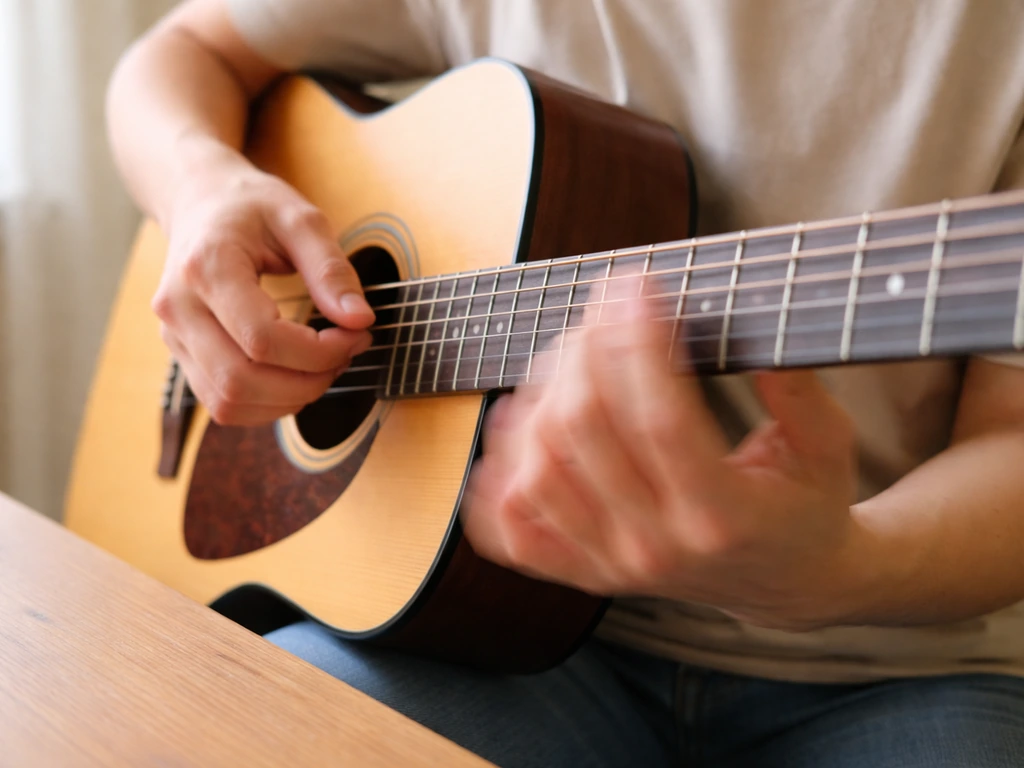 Close-up of hands strumming an acoustic guitar, showing a clear down-up strumming rhythm in action.