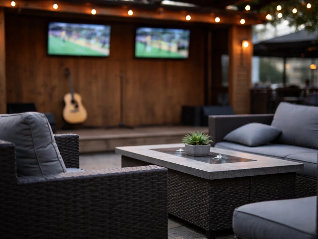 Quiet-ish outdoor patio scene with a small stage and sports TVs in the background, no people visible.