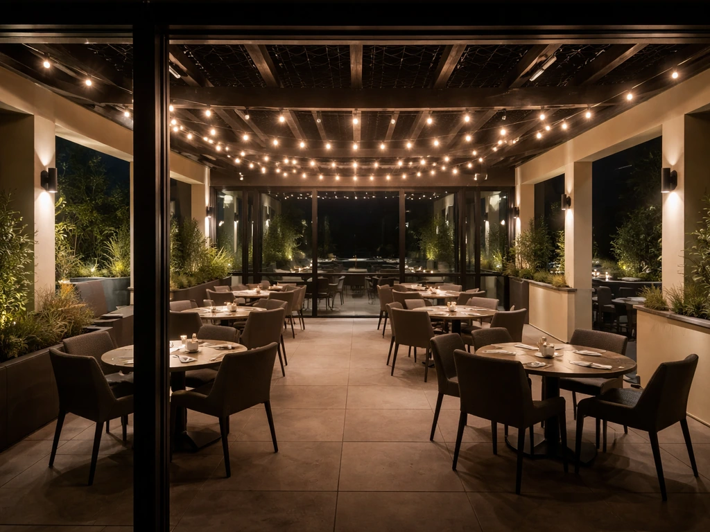 Wide view of a glass-enclosed main patio and adjacent side patio zones with warm lights at night.