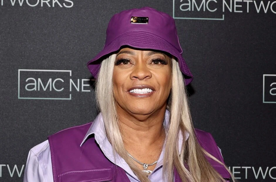 Deb Antney smiling at an AMC Networks event, wearing a purple hat and matching outfit.