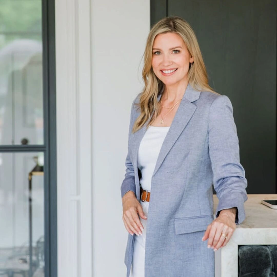Portrait of Kim Foster MD smiling in a light blazer indoors.