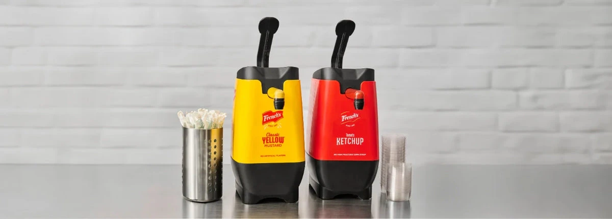 French's mustard and ketchup condiment dispensers on a countertop