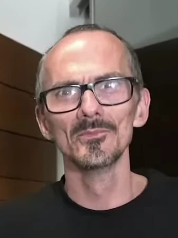 Portrait of French streamer Jean Pormanove (Raphaël Graven) wearing glasses and a black shirt.