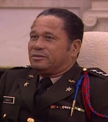 Henri Namphy in military uniform, seated in an interview setting
