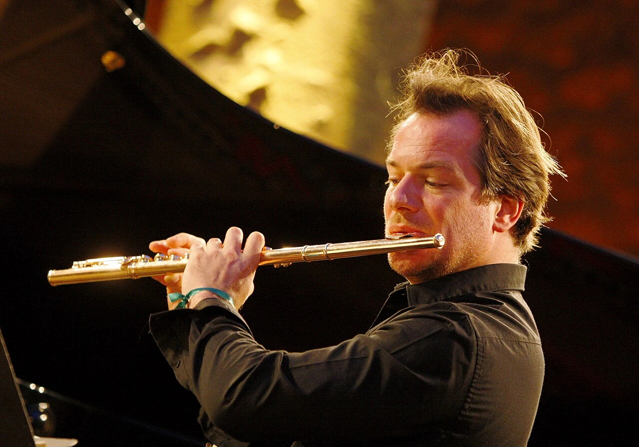 Emmanuel Pahud playing the flute on stage, in a concert performance photo.