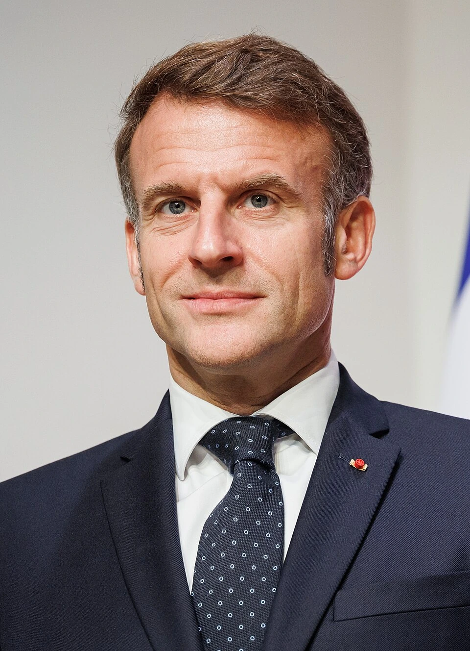 Portrait photo of Emmanuel Macron in a suit and tie.
