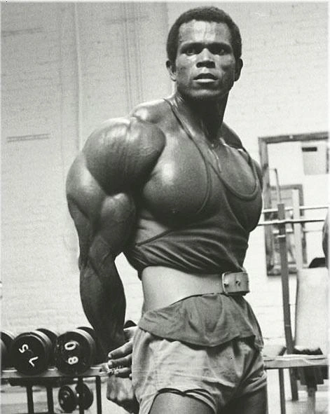Serge Nubret posing in a gym, black-and-white photo