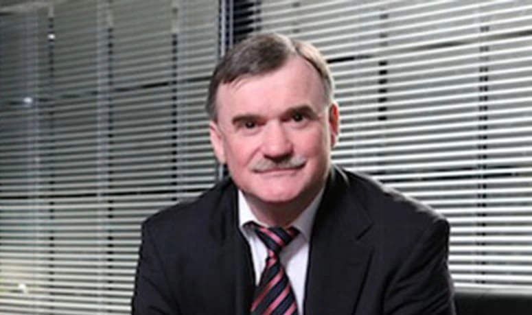 Portrait of Serge Belamant in a suit and tie in an office setting