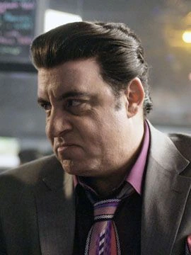 Silvio Dante from The Sopranos in a suit, shown in a close-up promotional still