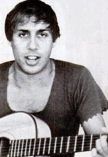 Adriano Celentano holding a guitar in a black-and-white portrait photo from 1970.
