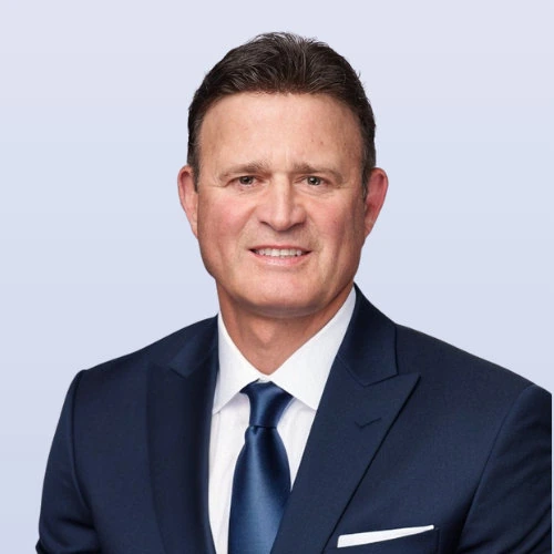 Portrait of Dino Trevisani in a suit and tie against a light background