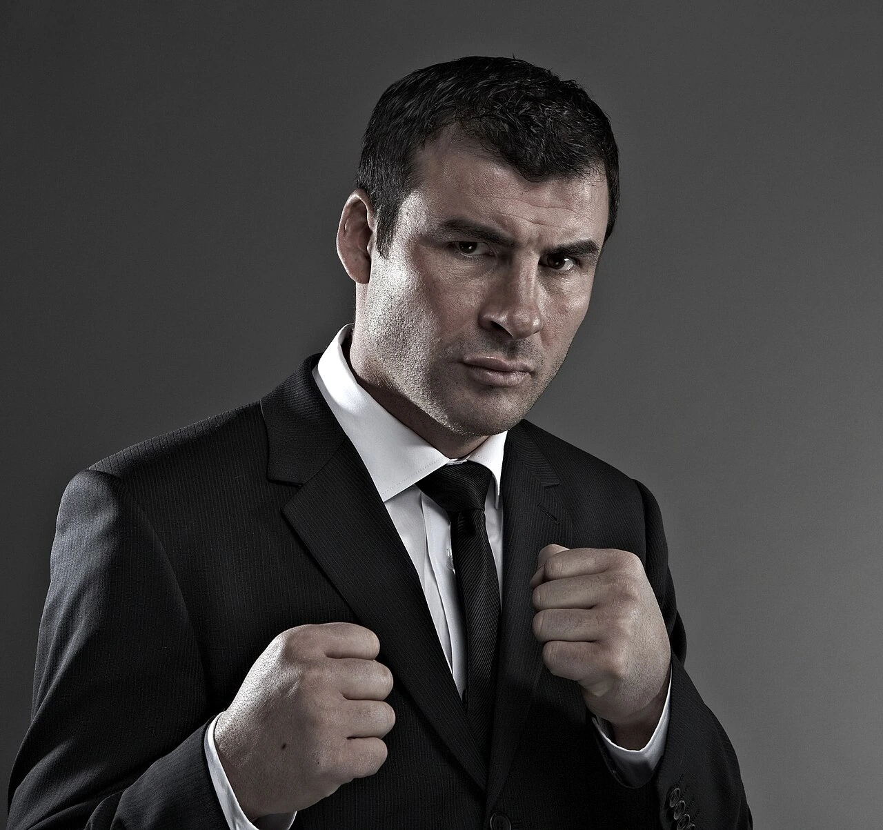Joe Calzaghe in a studio portrait wearing a suit and boxing stance