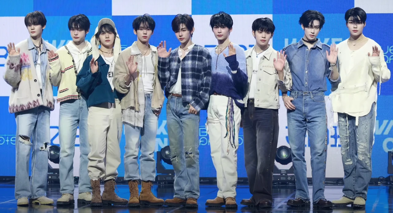 ZEROBASEONE at a Blue Paradise media showcase, posing on stage with hands raised