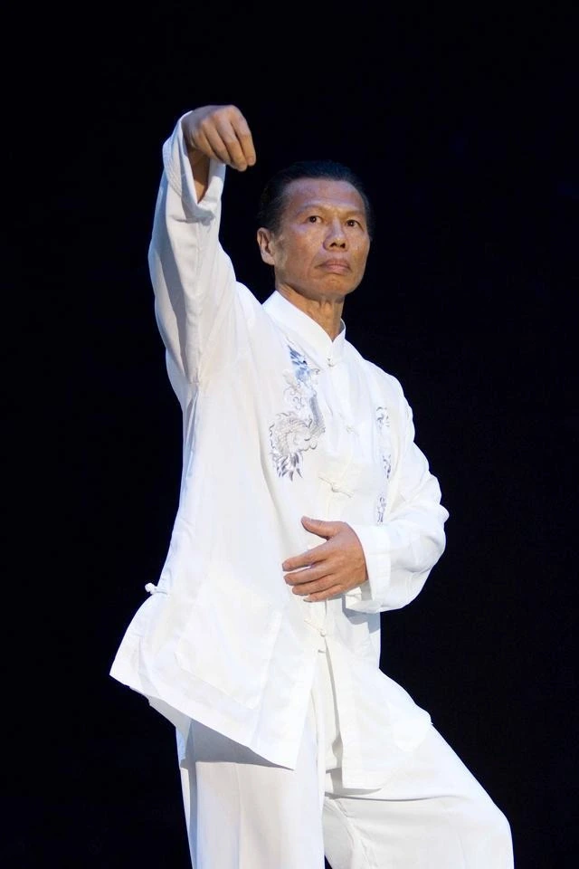 Bolo Yeung in a white martial arts outfit performing a pose
