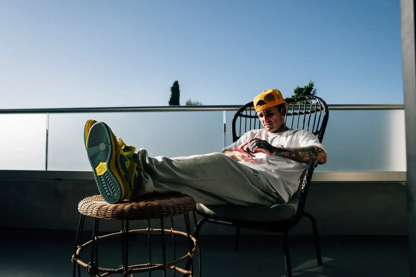 Mikki Mase relaxing outdoors on a chair with one leg propped up